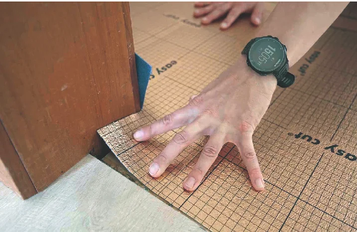 Person verlegt Dämmunterlage auf Boden.